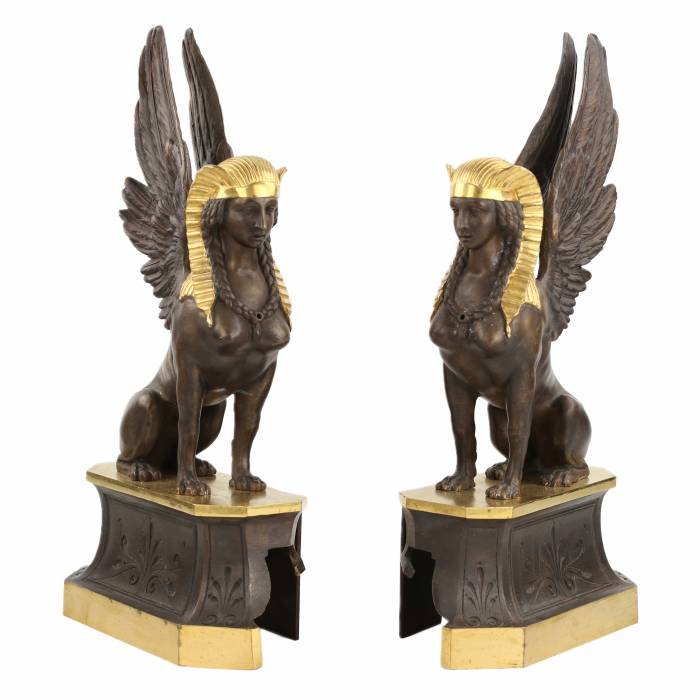 Une paire de bûchers en bronze patiné et doré se présente en forme de sphinx ailés. 19ème siècle. 