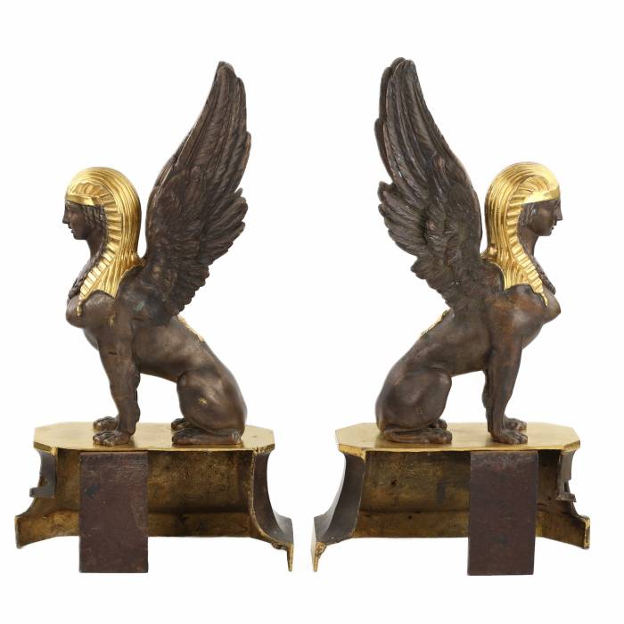 Une paire de bûchers en bronze patiné et doré se présente en forme de sphinx ailés. 19ème siècle. 