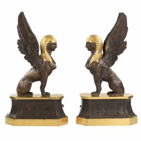 Une paire de bûchers en bronze patiné et doré se présente en forme de sphinx ailés. 19ème siècle. 